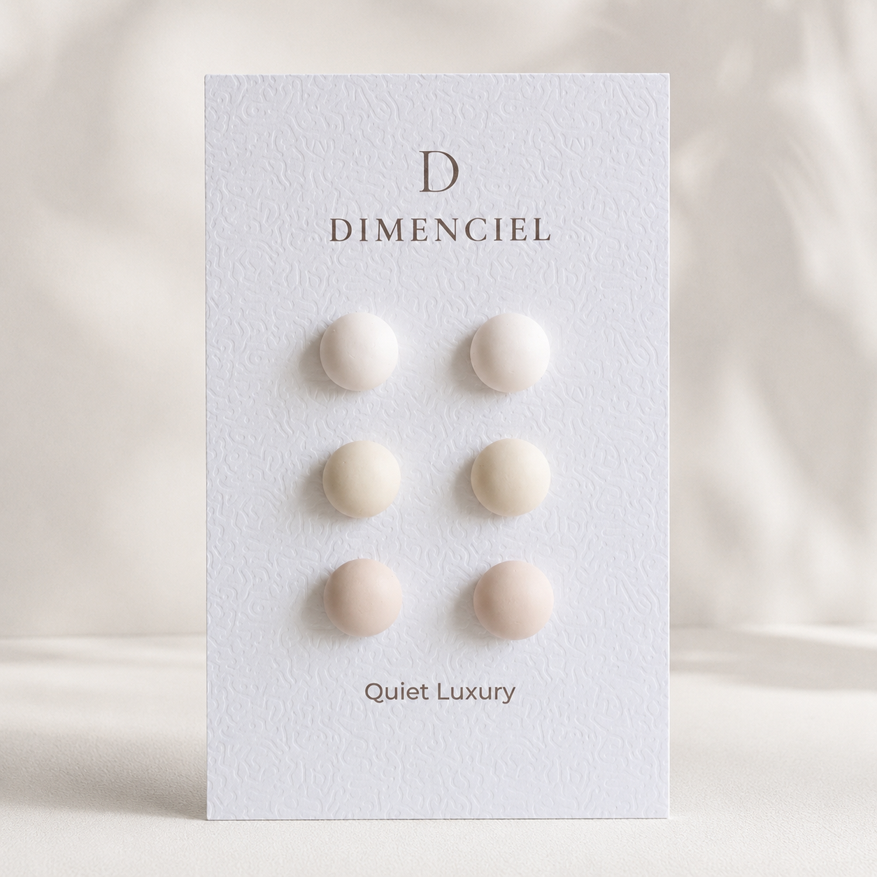 The Micro Dome Trio in Quiet Luxury — Bone, Oatmeal, Greige dome ear studs on Dimenciel branded card