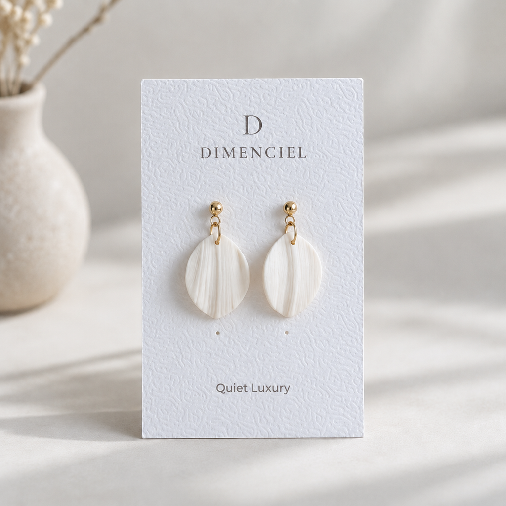 The Petal Drop in Quiet Luxury — Bone polymer clay petal drop earrings with gold hardware on Dimenciel branded card