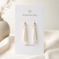 The Tapered Drop in Quiet Luxury — Bone polymer clay tapered drop earrings with gold hardware on Dimenciel branded card