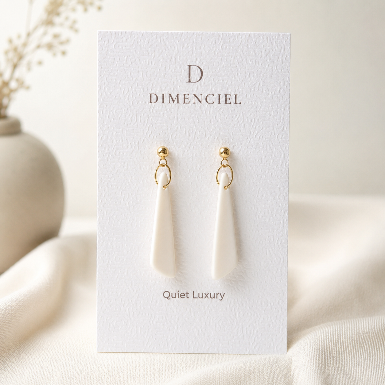 The Tapered Drop in Quiet Luxury — Bone polymer clay tapered drop earrings with gold hardware on Dimenciel branded card
