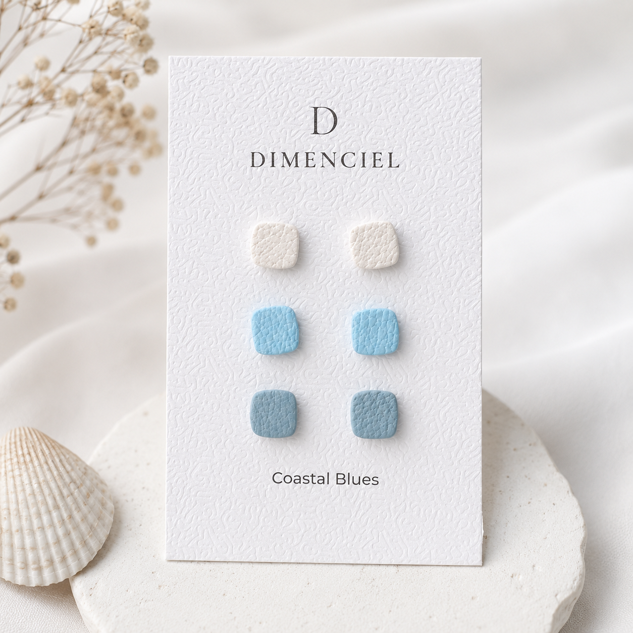 Coastal Blues Square Ear Studs Set — three pairs of square studs in white, sky blue, and slate blue on a Dimenciel branded card