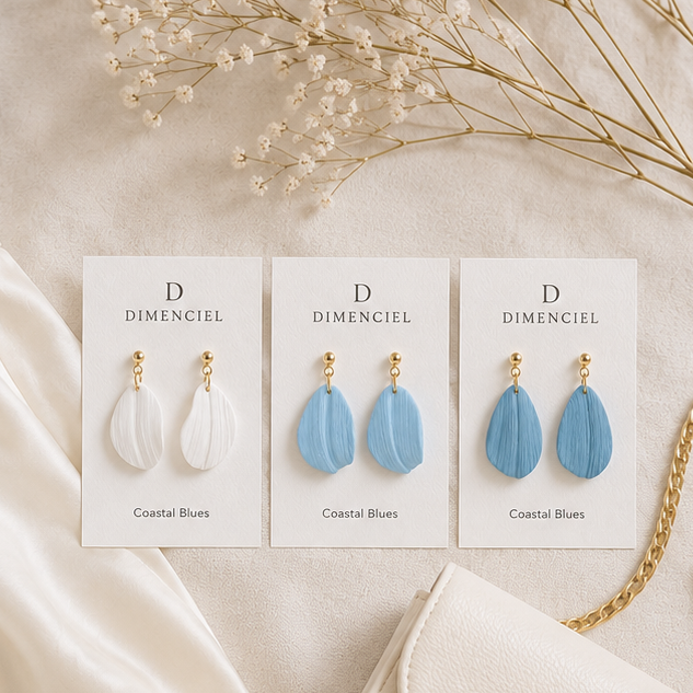 Coastal Blues Petal Drop Earrings — three pairs in Sea Salt, Mist Blue, and Slate Blue on Dimenciel branded cards styled with a cream skirt and blue cardigan
